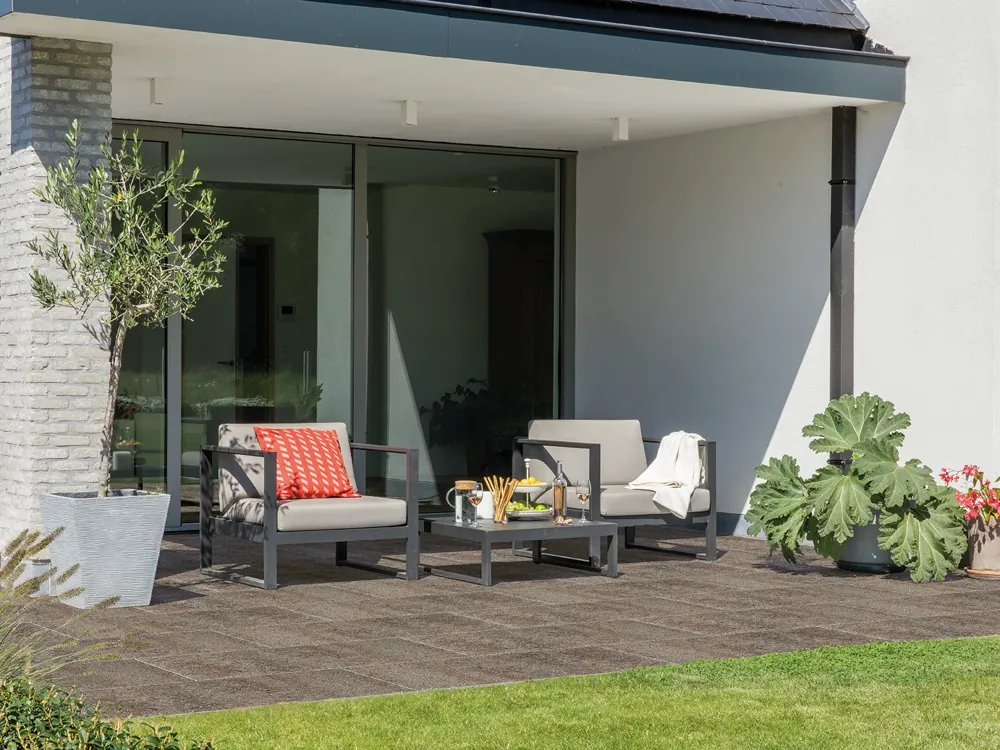 Terrasse en dalles Infinito Comfort Tavo 80×40 devant une maison contemporaine, salon de jardin